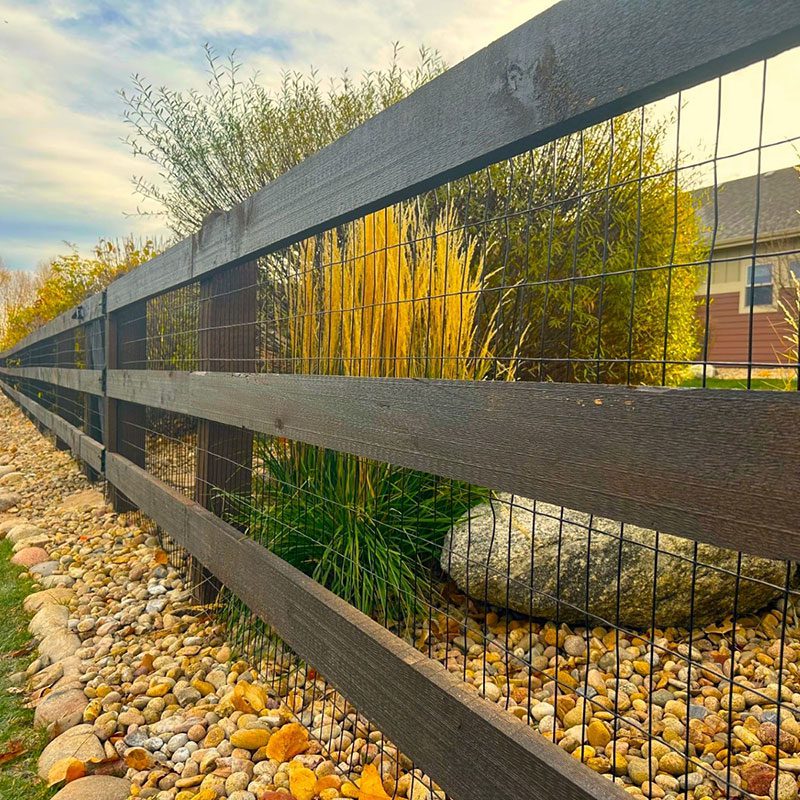 close up of post and rail fence with wire