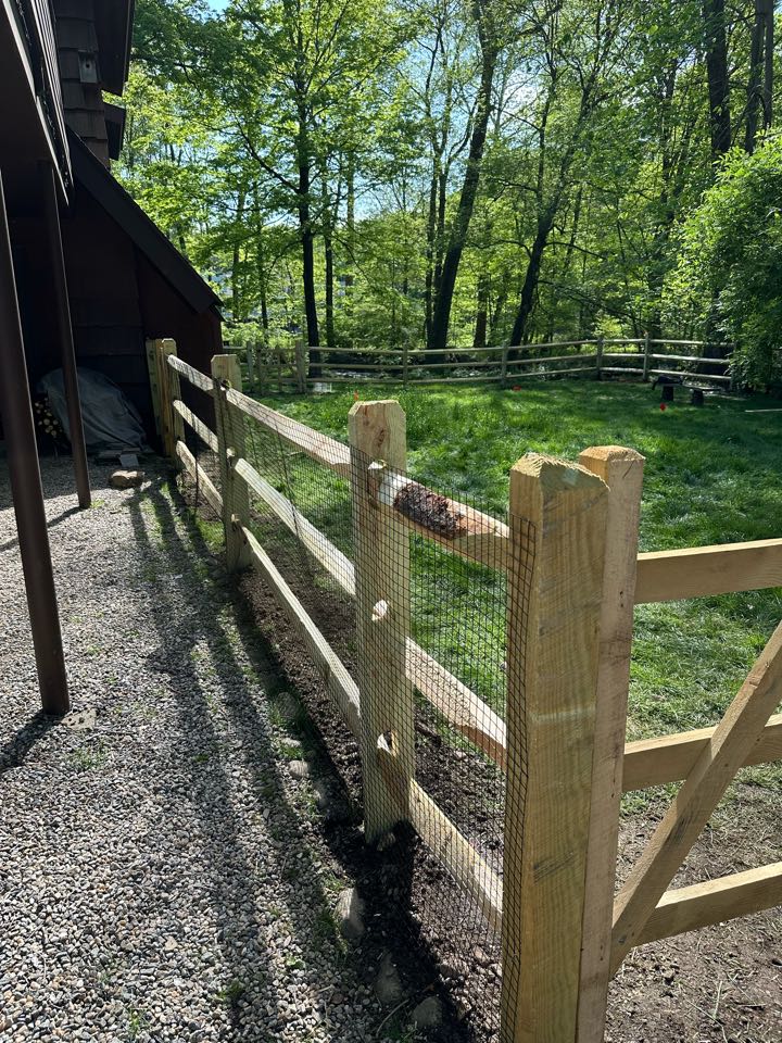 Finishing up a pressure treated split rail fence with welded wire attached to keep the dogs safe in Norwalk (Silvermine)!