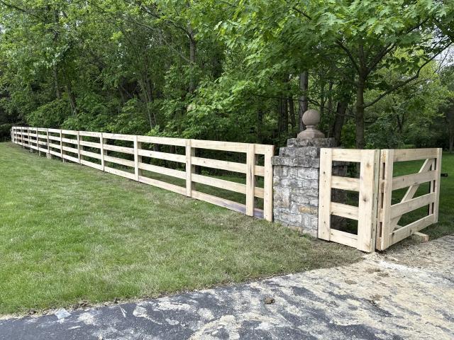117 feet of 4’ high poplar 4 rail fence installed with a double swing driveway gate. 