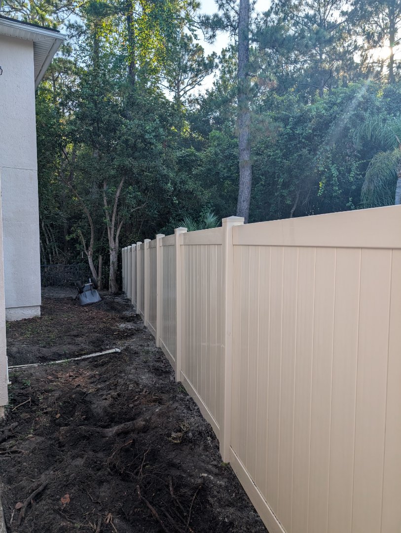 Tan vinyl fence as part of a backyard renovation 