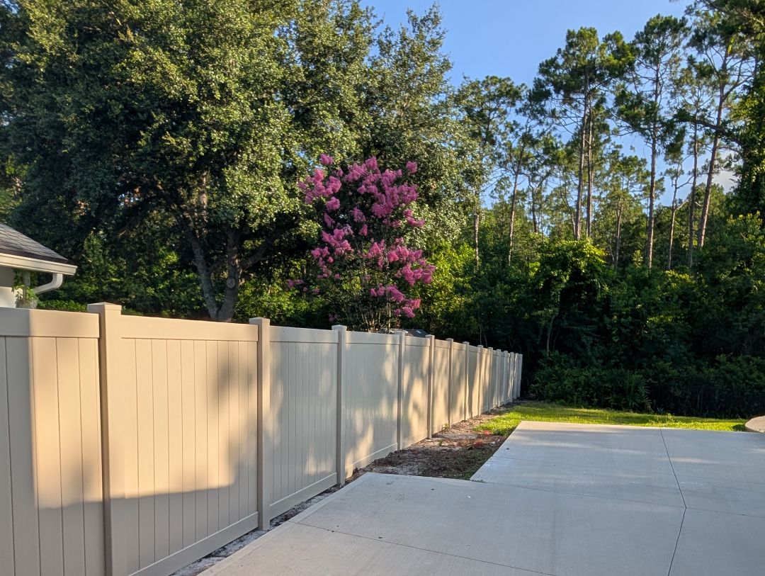 Tan vinyl fence as part of a backyard renovation 