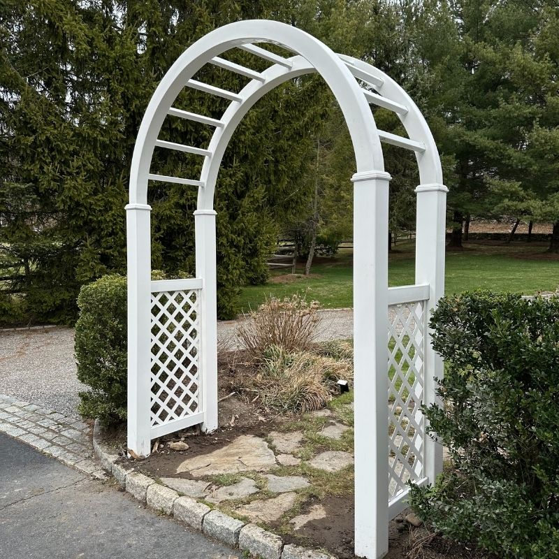A new white vinyl arbor and replacement of a cedar arbor top, painted white by Top Rail Fence