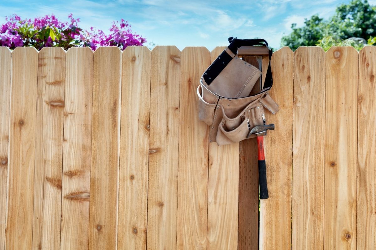 Cedar fence with work belt hanging on it