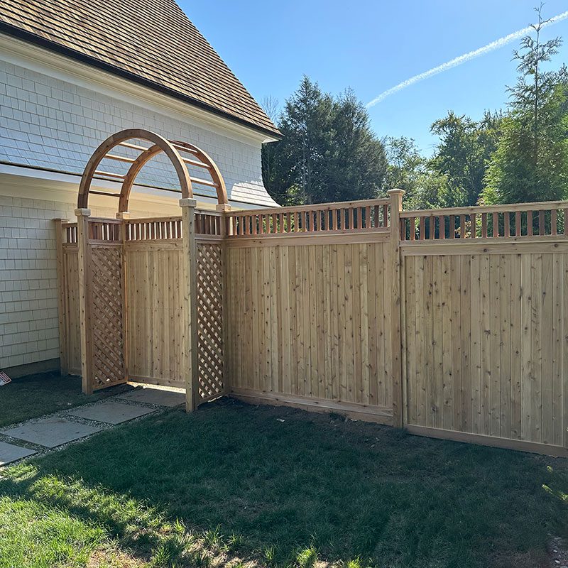 stockade fence with lattice trim and ornate arch