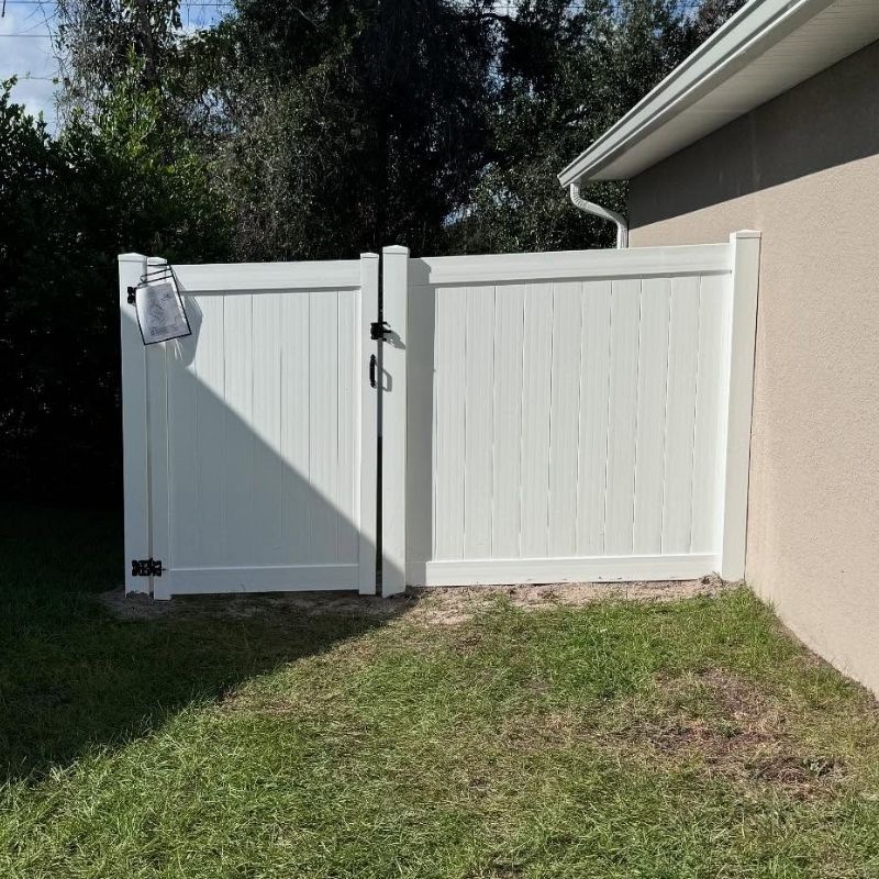 white vinyl gate and fence attached to a house